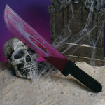Pink machete with black handle on a skull and tombstone with spider webs